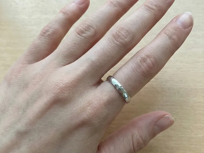 槌目リングをした女性の手の画像